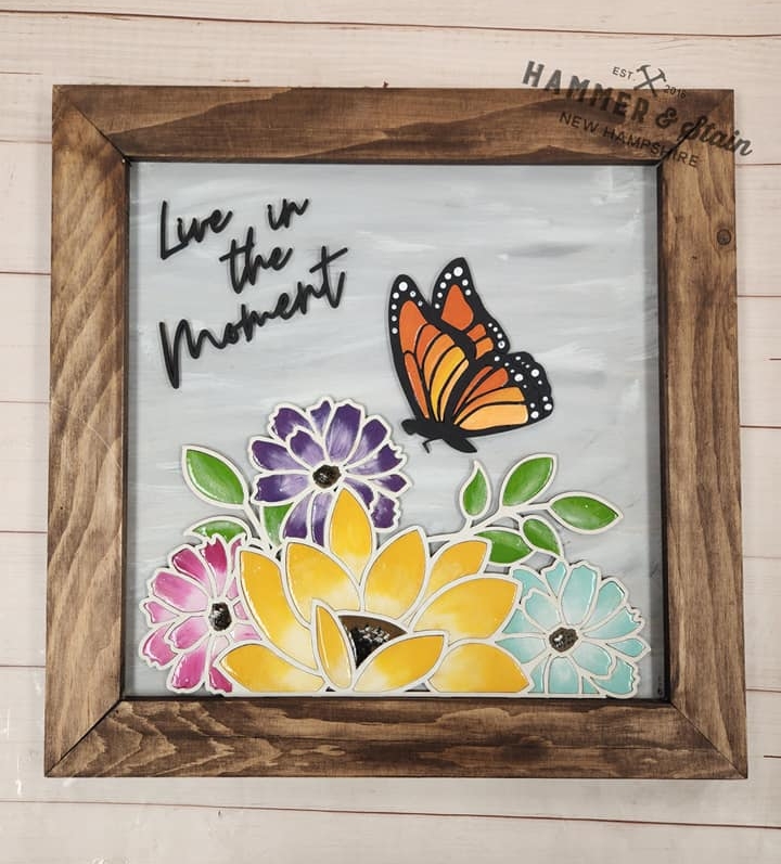 A picture frame with a butterfly and flowers on it.