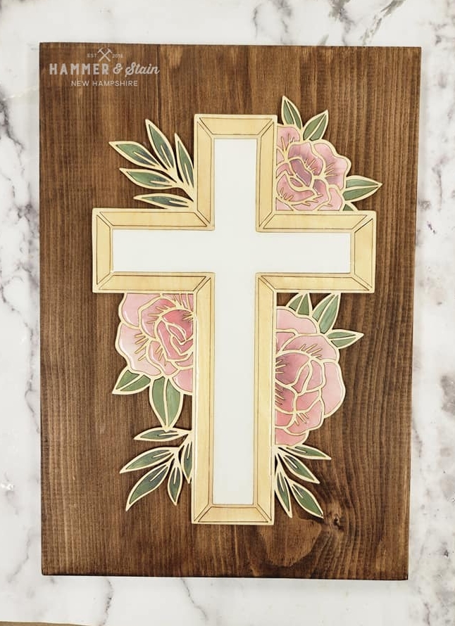 A cross with flowers on it is painted gold.